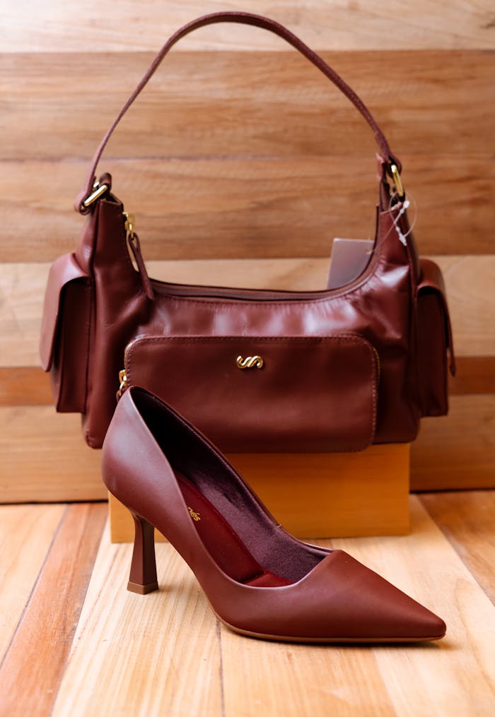 Stylish brown handbag and pointed-toe heels displayed together on a wooden floor for a chic fashion statement.